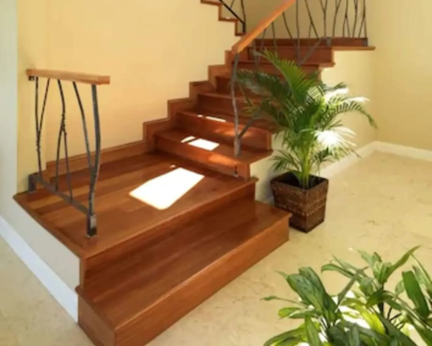 Cottage Seven wooden staircase with metal railing and plants at Jamaica Inn.