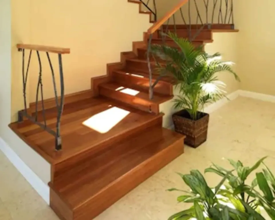 Cottage Seven wooden staircase with metal railing and plants at Jamaica Inn.