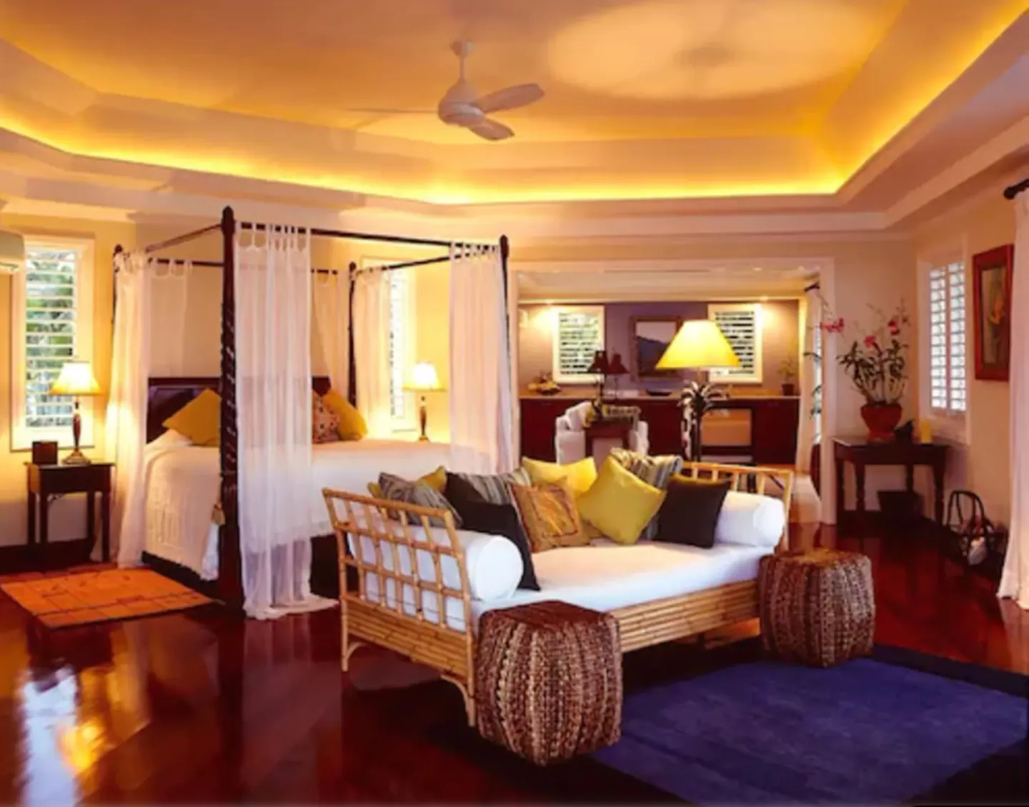 Cottage Three at Jamaica Inn with a four-poster bed, sofa seating, and warm cove lighting.