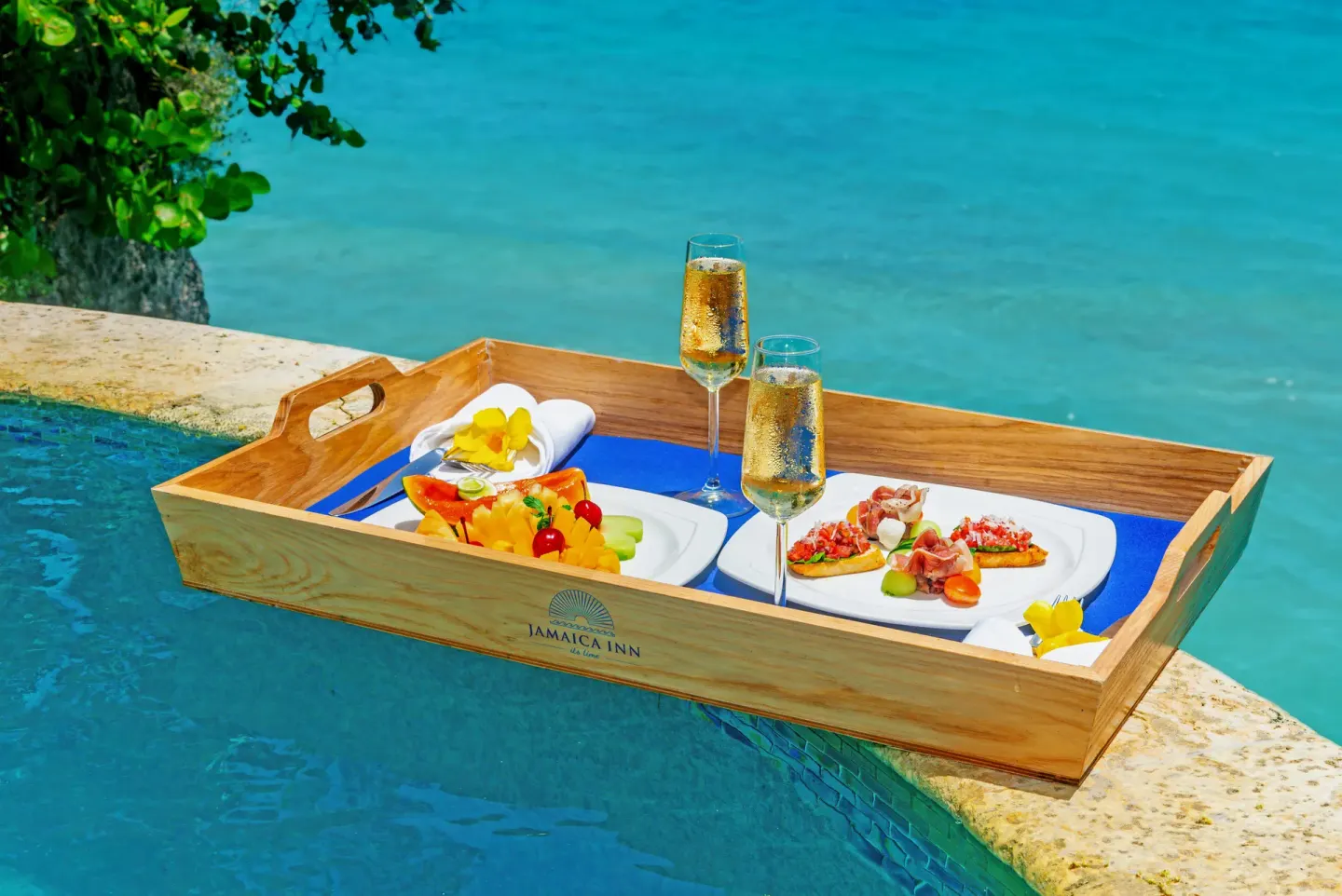 Cottage Three at Jamaica Inn with a poolside tray of drinks and small plates by the sea.