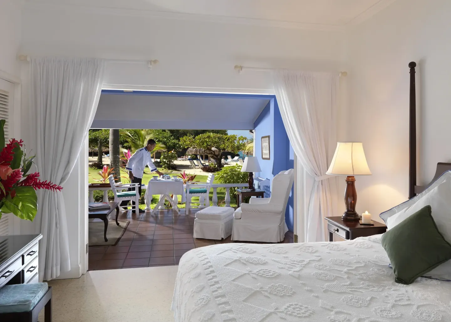 Deluxe Suite bedroom opens to a furnished verandah at Jamaica Inn.