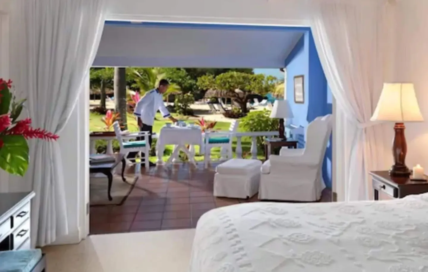 Deluxe Suite bedroom with open curtains to a breakfast verandah at Jamaica Inn.