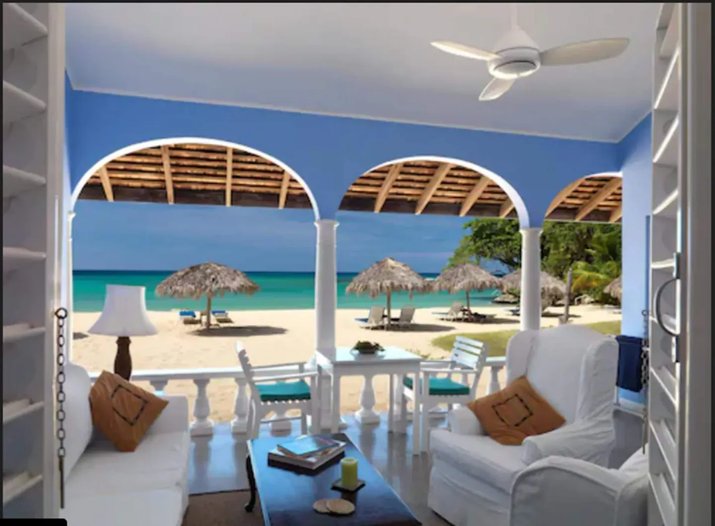 Premier Suite verandah with white seating and beach view at Jamaica Inn.