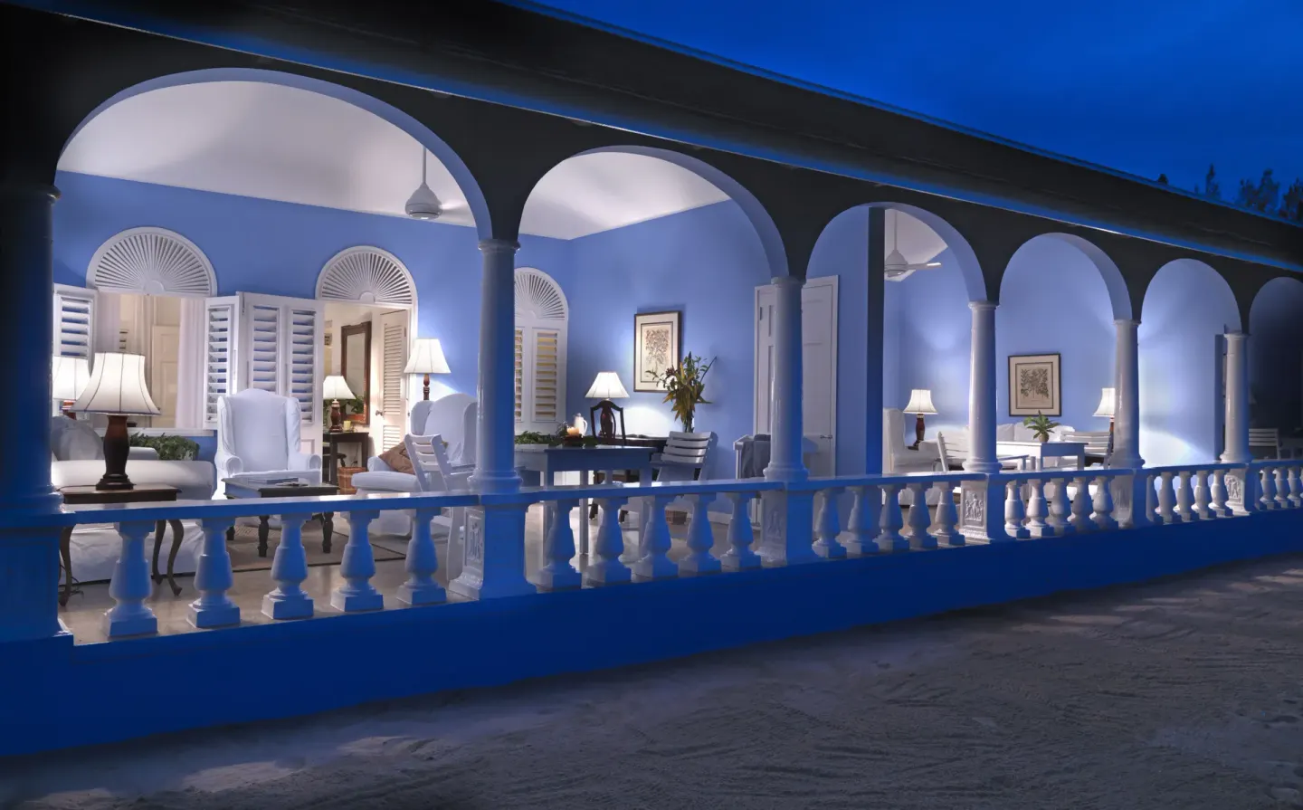 Premier Suite verandah lit at night with arches and lounge seating at Jamaica Inn.