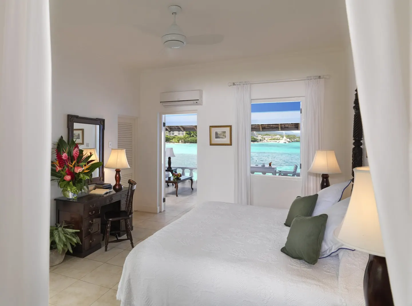 Premier Suite bedroom with sea-facing window and verandah doorway at Jamaica Inn.