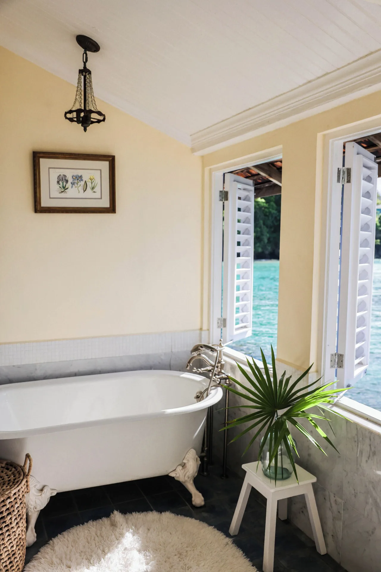 Suite 21 bathroom at Jamaica Inn with a clawfoot tub beside shuttered windows overlooking the water.