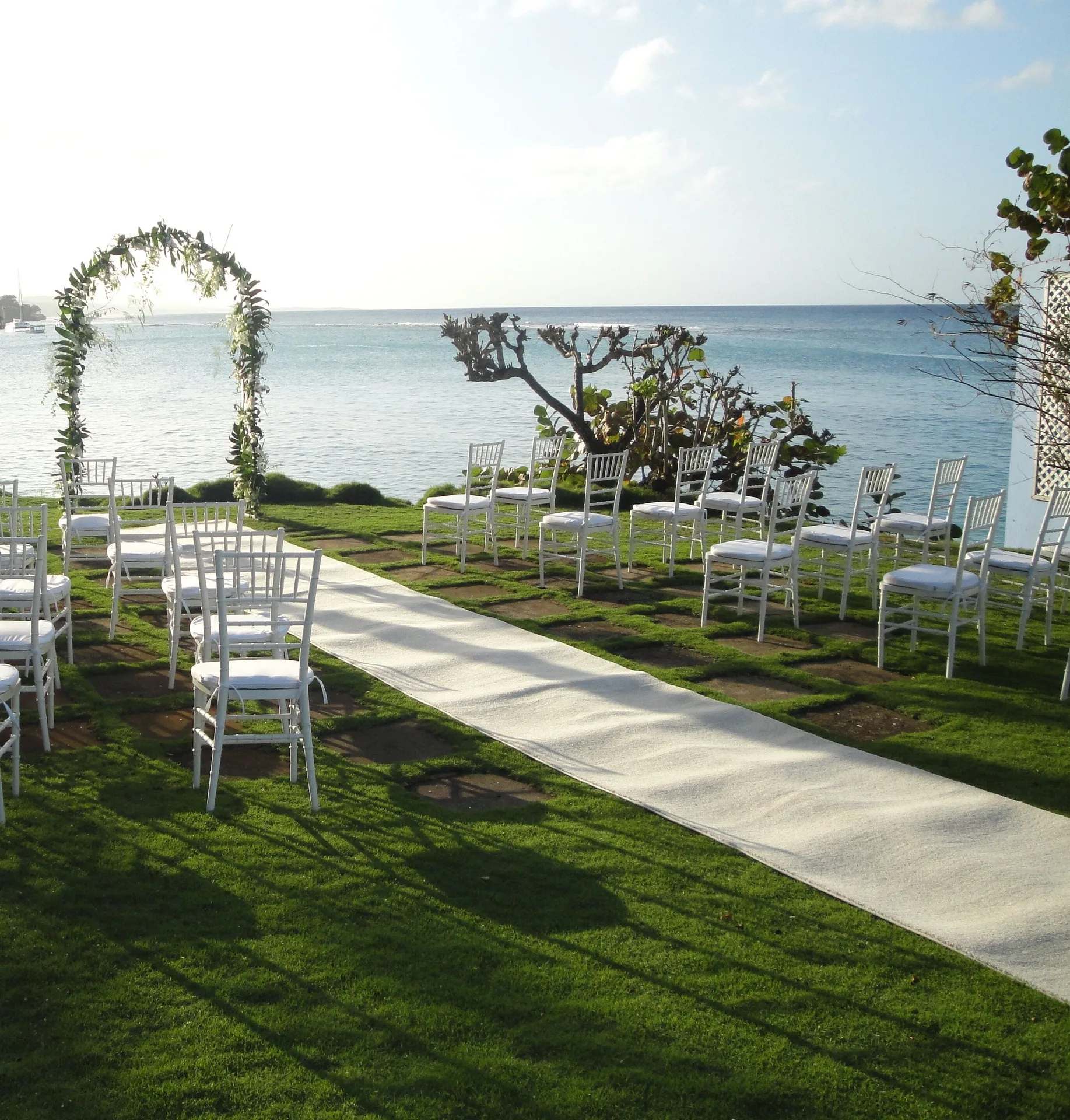 Seaside wedding ceremony setup with white chairs at Jamaica Inn.