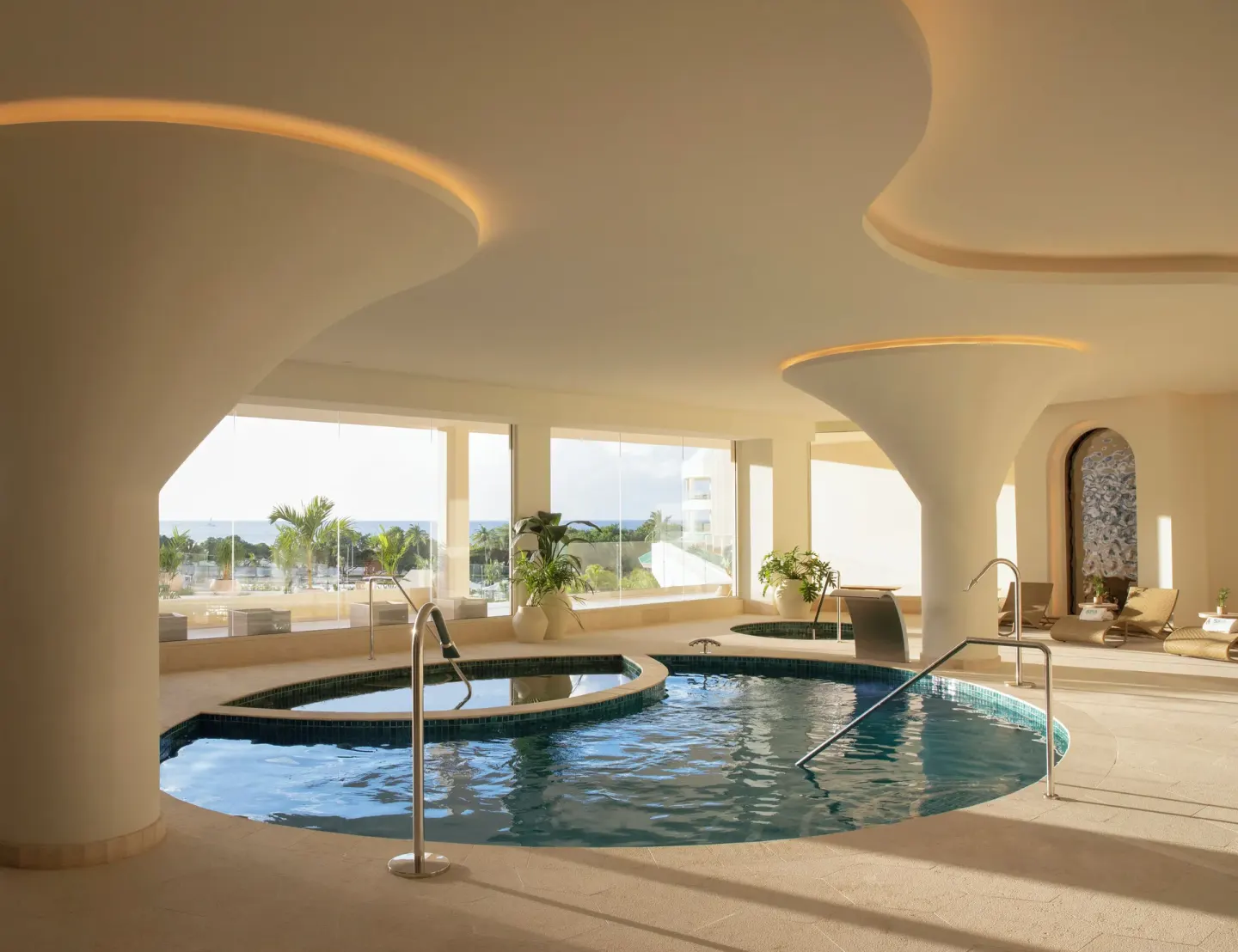 Indoor hydrotherapy pools with ocean-facing windows at JOIA Aruba.
