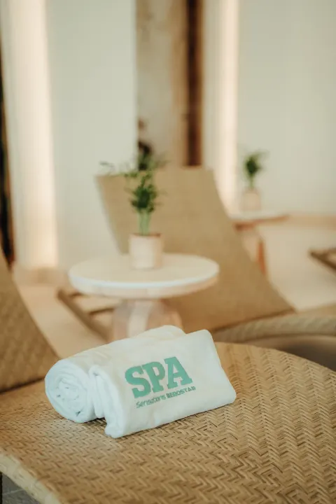Rolled spa towel on a woven lounge chair at JOIA Aruba.