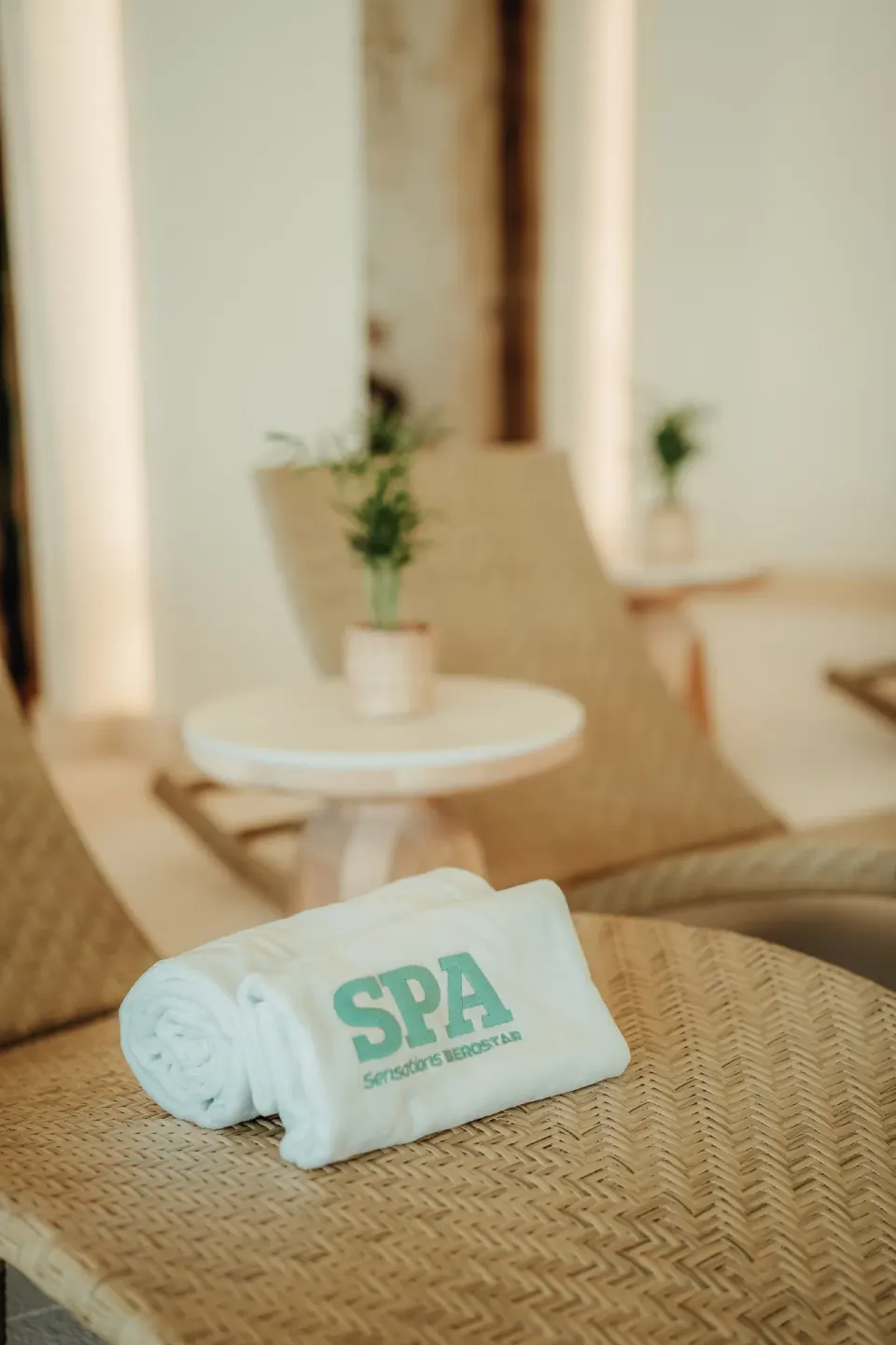 Rolled spa towel on a woven lounge chair at JOIA Aruba.