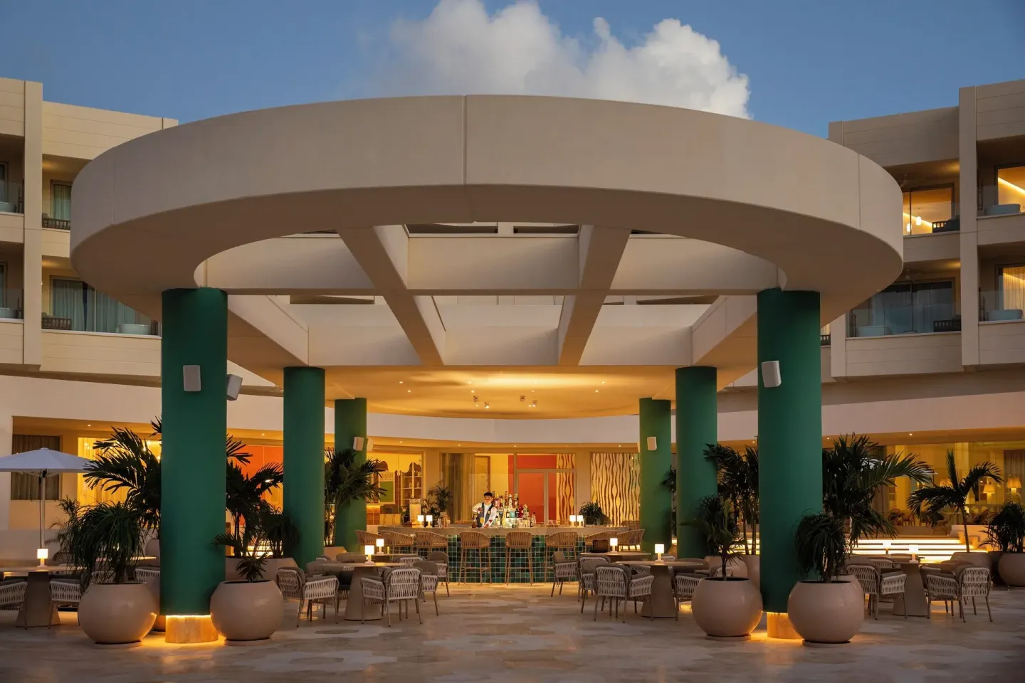 An illuminated open-air bar and seating area sits beneath a round canopy at JOIA Aruba.