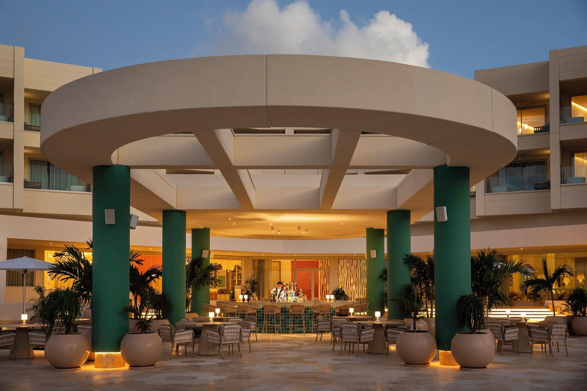 An illuminated open-air bar and seating area sits beneath a round canopy at JOIA Aruba.