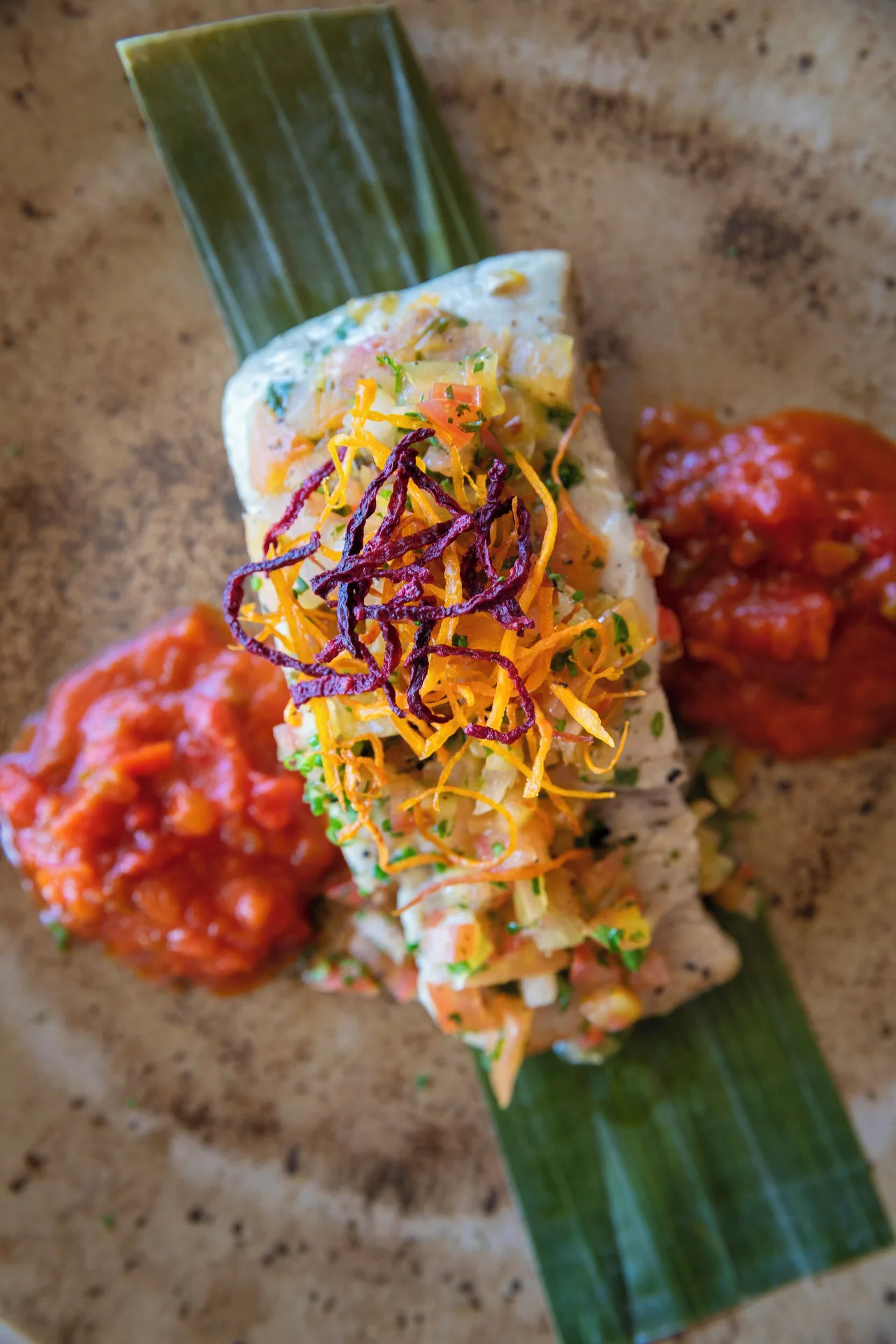 Wrapped seafood-style dish with red sauce on a plate at JOIA Aruba.