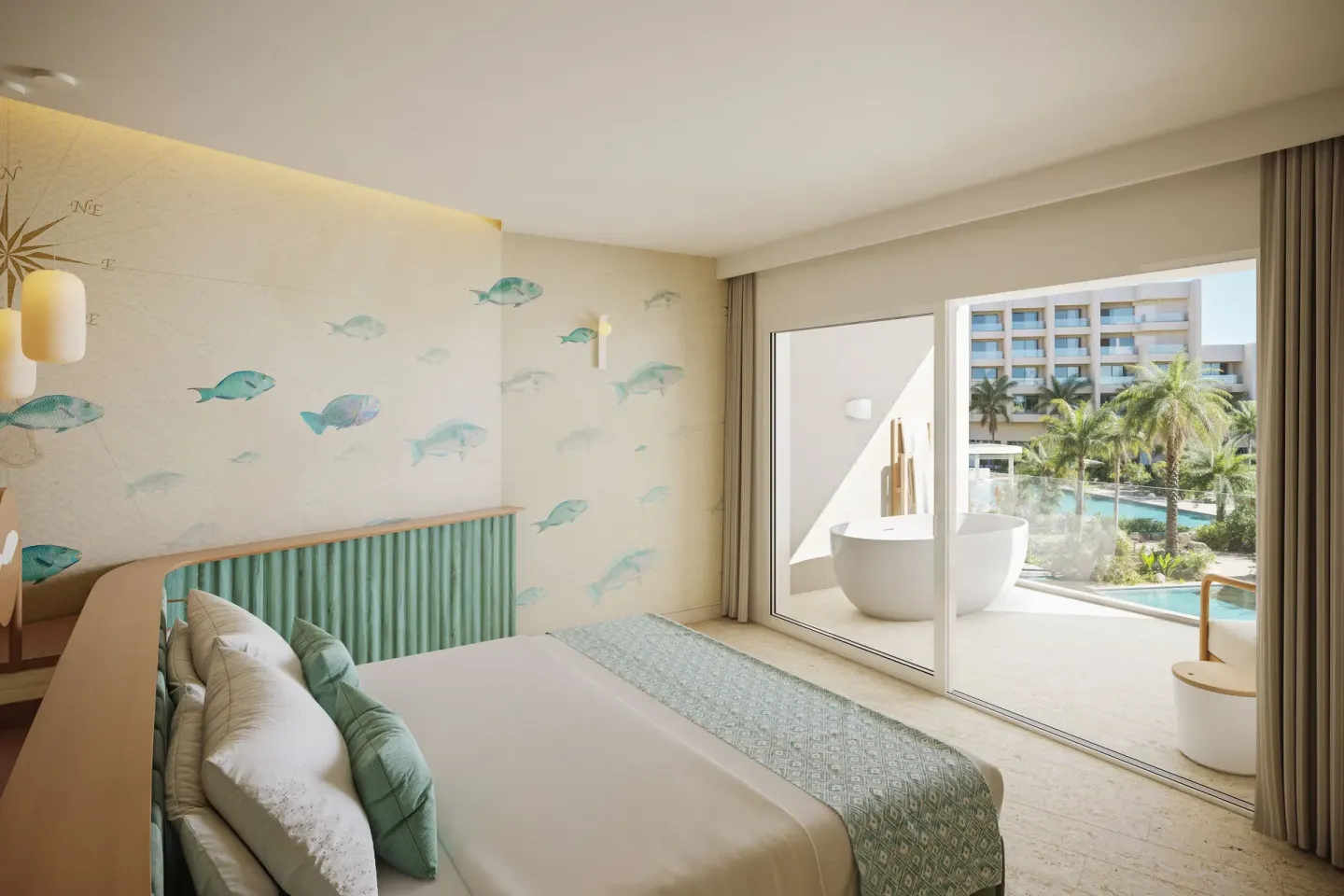 Pool View Suite bedroom with king bed, balcony tub, and pool-facing view at JOIA Aruba.