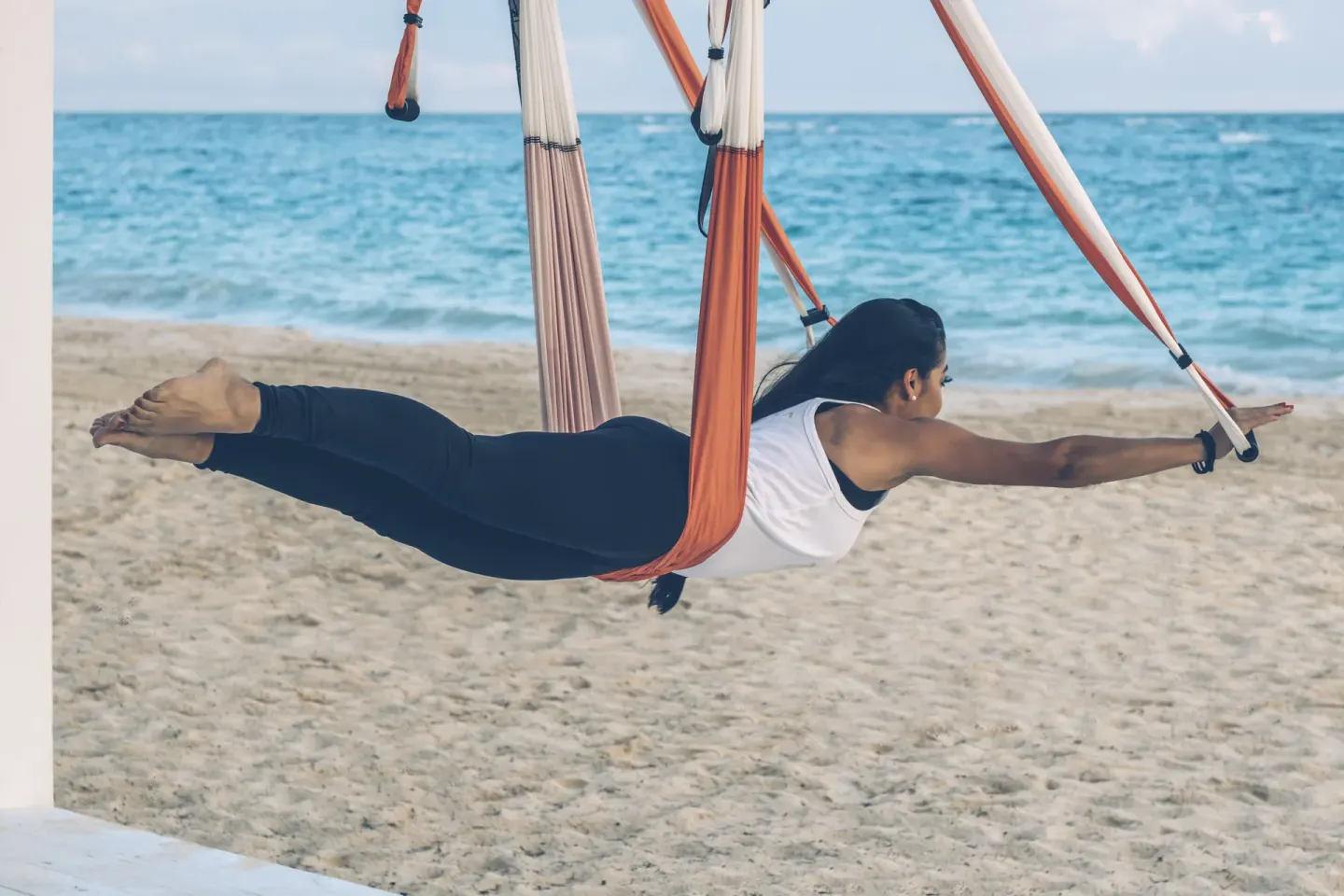 Aerial yoga hammock session on the beach at JOIA Bávaro by Iberostar.