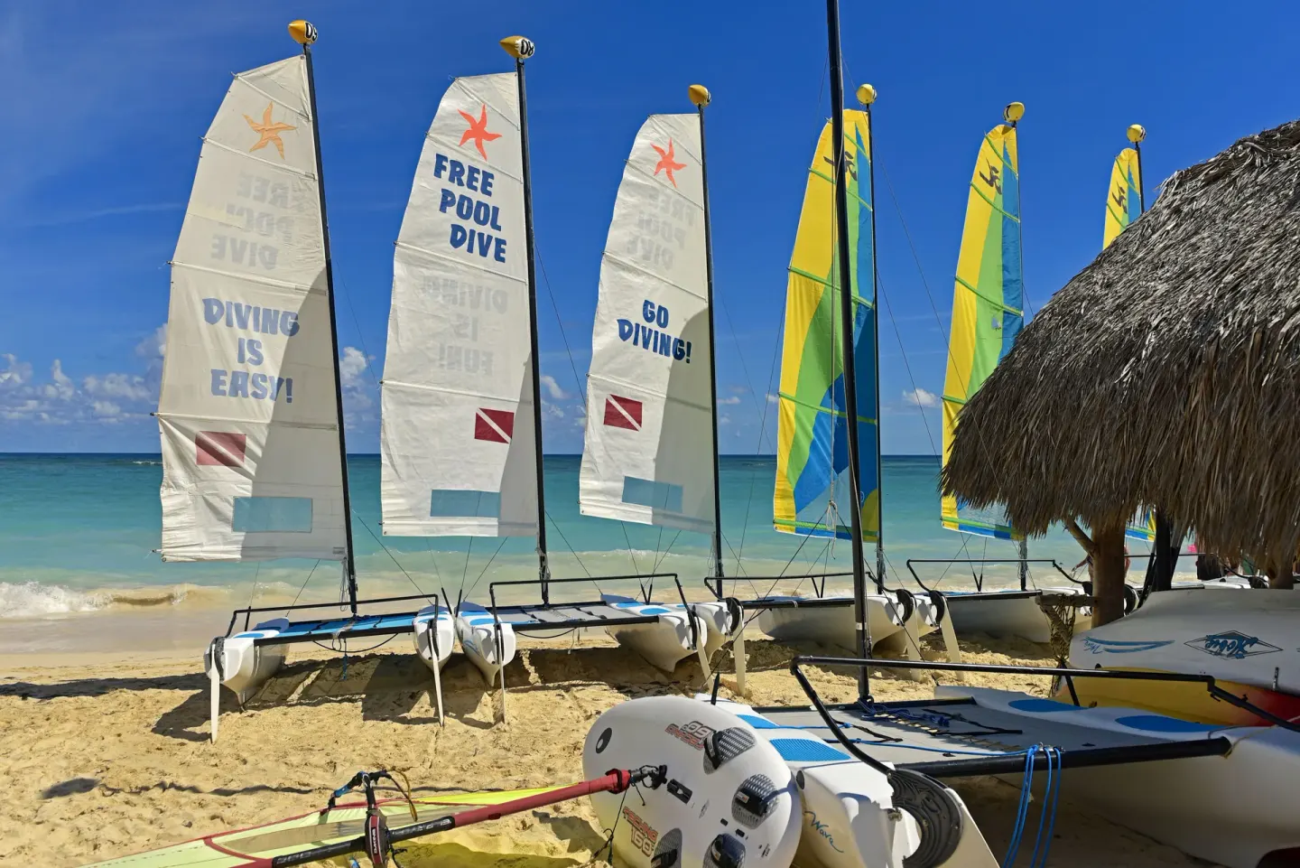 Catamarans and beach watersports gear on the sand at JOIA Bávaro by Iberostar.