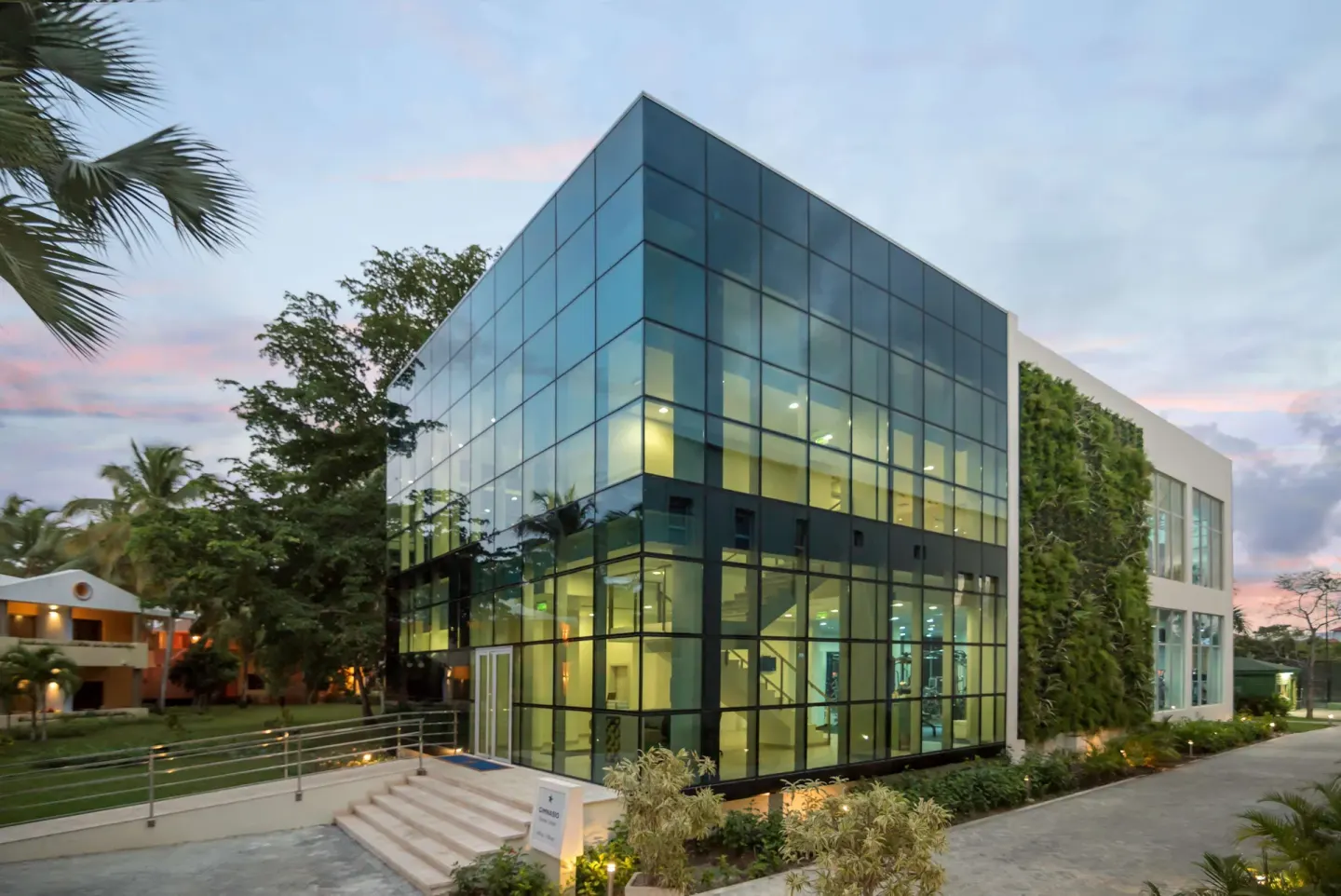 Modern glass-walled fitness building at dusk at JOIA Bávaro by Iberostar.