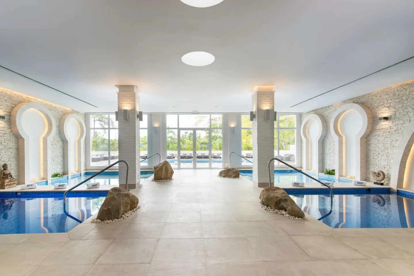 Indoor spa pools with arched wall details at JOIA Bávaro by Iberostar.