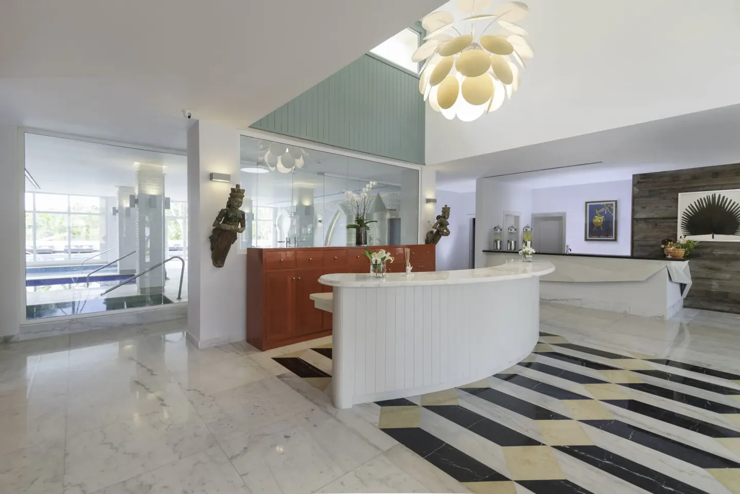 Spa reception desk with chandelier and pool entrance at JOIA Bávaro by Iberostar.