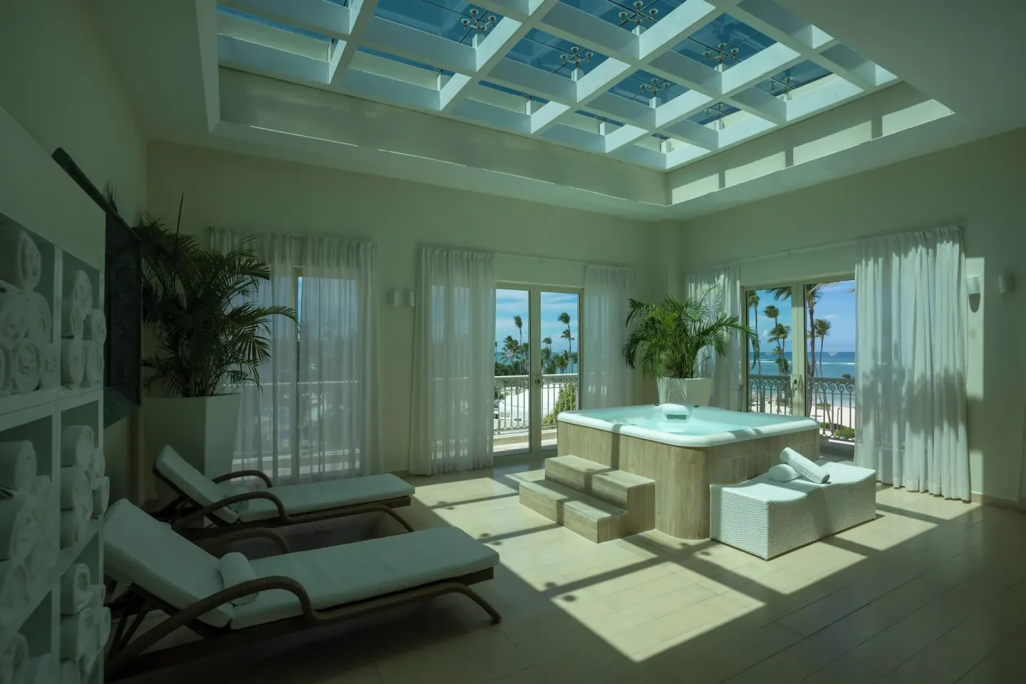 Sunlit spa relaxation room with hot tub and ocean view at JOIA Bávaro by Iberostar.