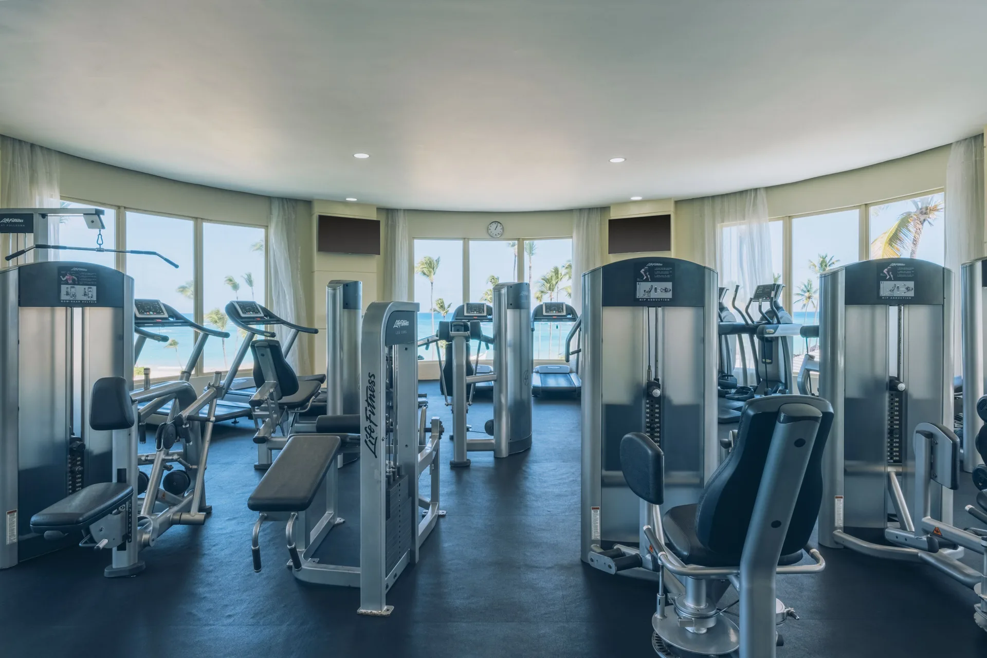 Gym with strength machines and ocean-facing windows at JOIA Bávaro by Iberostar.