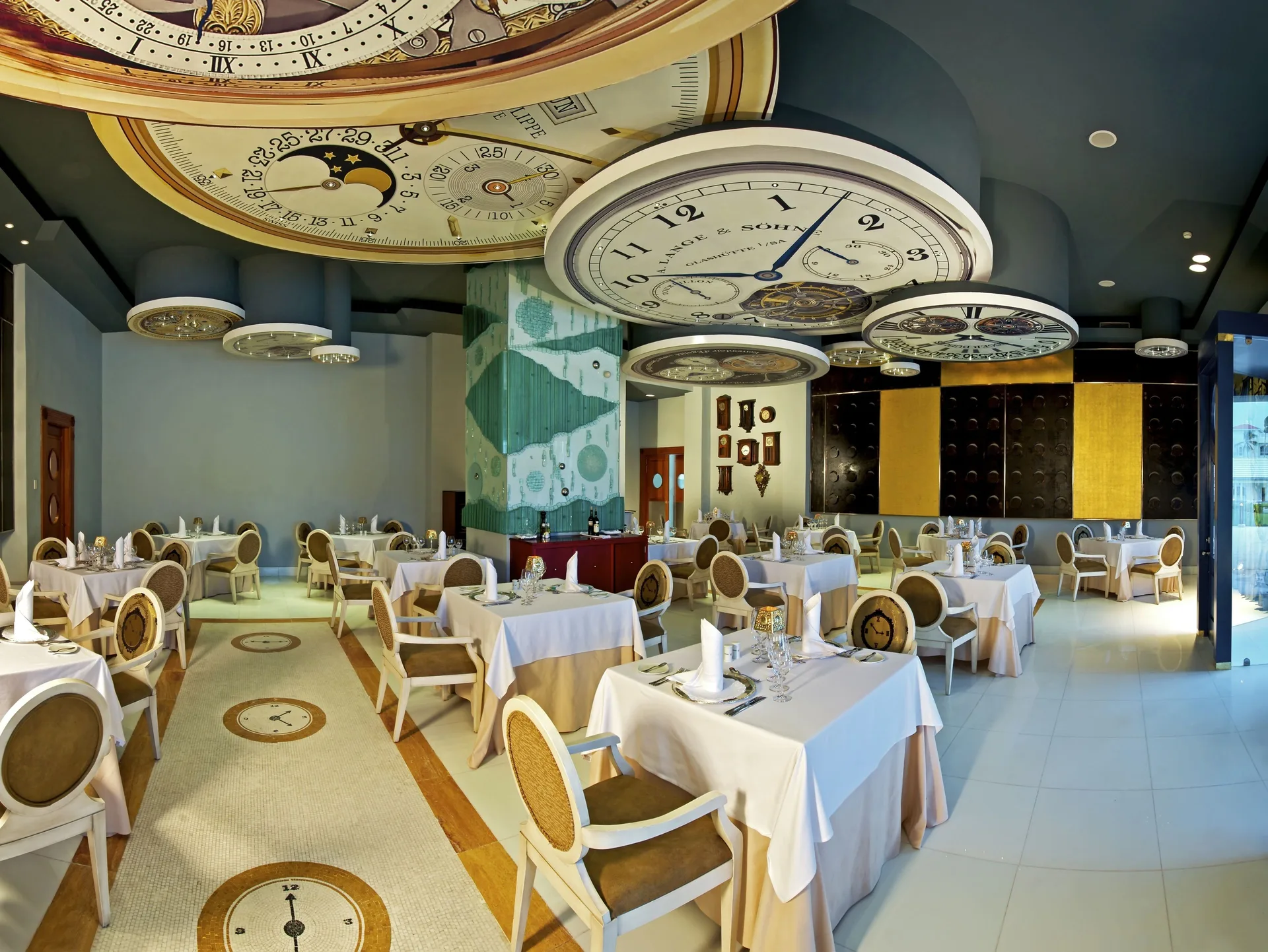 Clock-themed dining room with set tables at JOIA Bávaro by Iberostar.