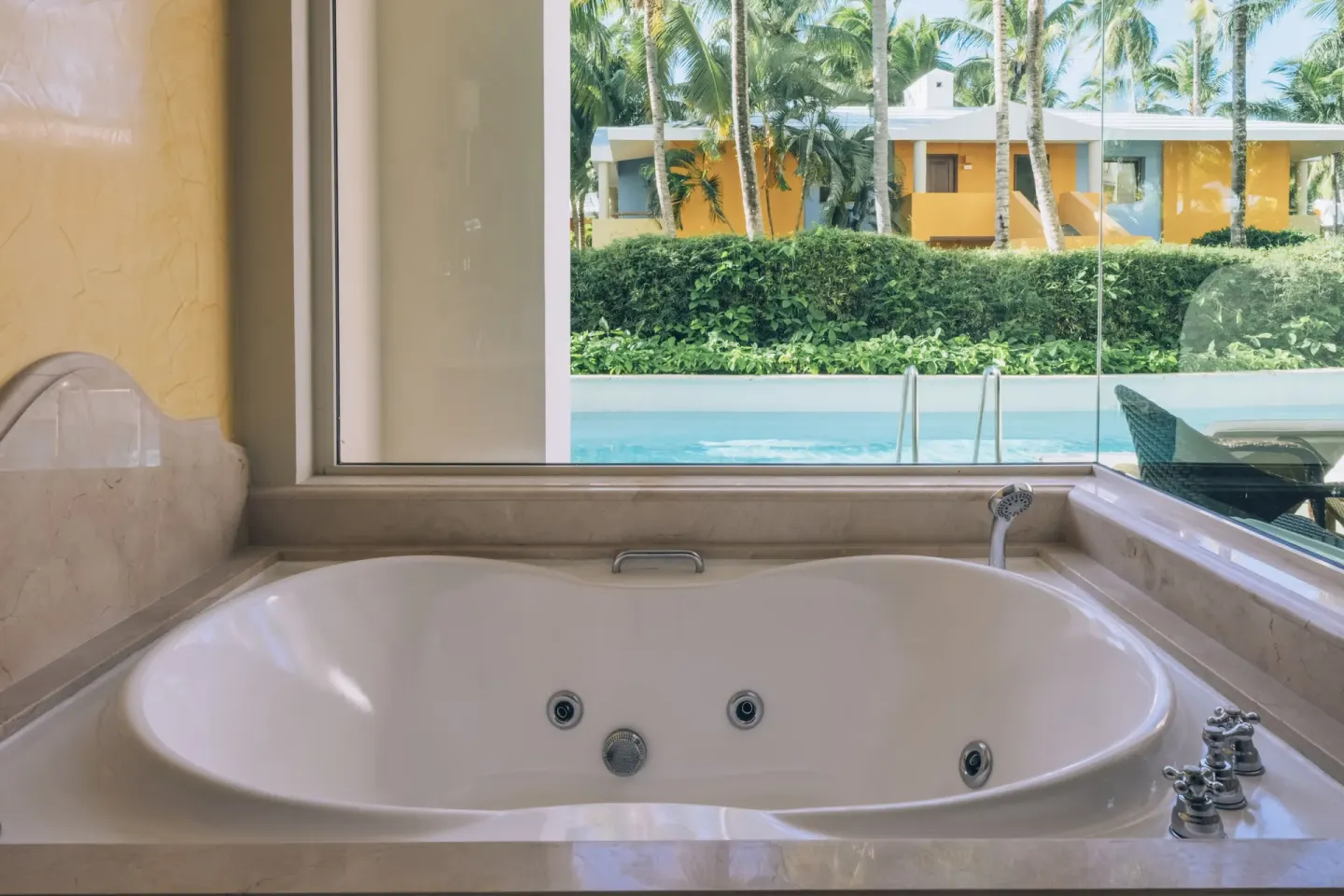 Bathroom whirlpool tub facing the swim-out pool at JOIA Bávaro by Iberostar.