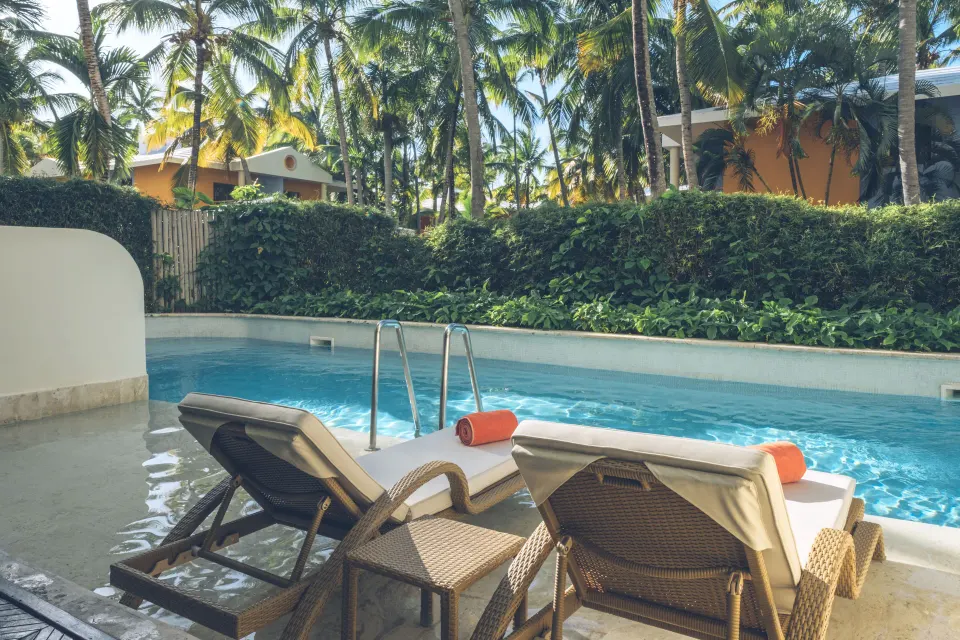 Swim Out suite patio loungers overlooking the pool at JOIA Bávaro by Iberostar.