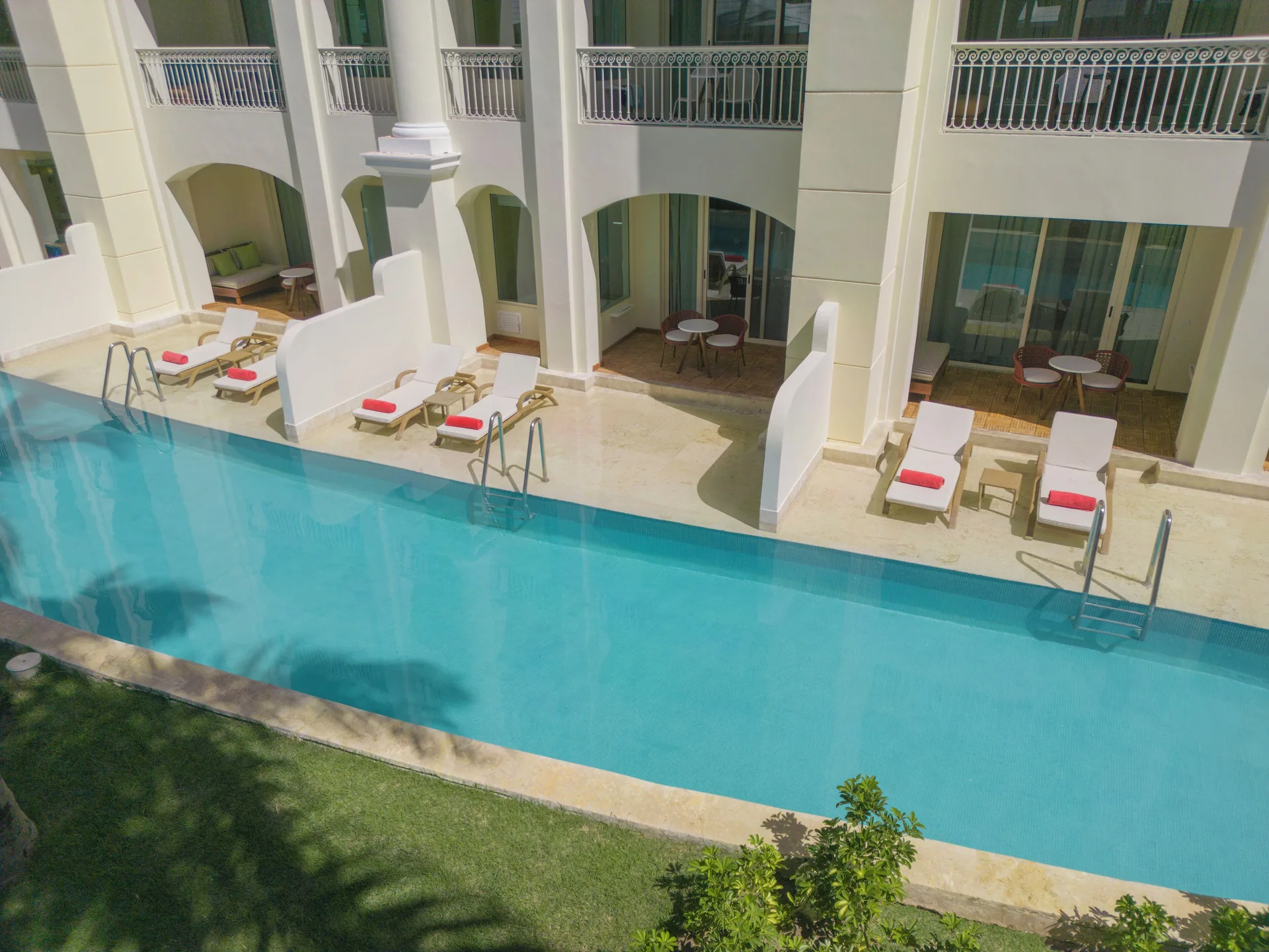Swim Out suite patios beside a long pool at JOIA Bávaro by Iberostar.