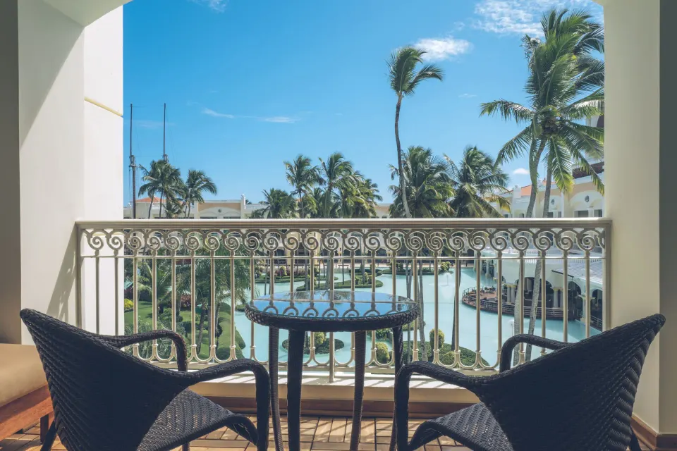 Suite Lake View balcony seating facing the lagoon at JOIA Bávaro by Iberostar.