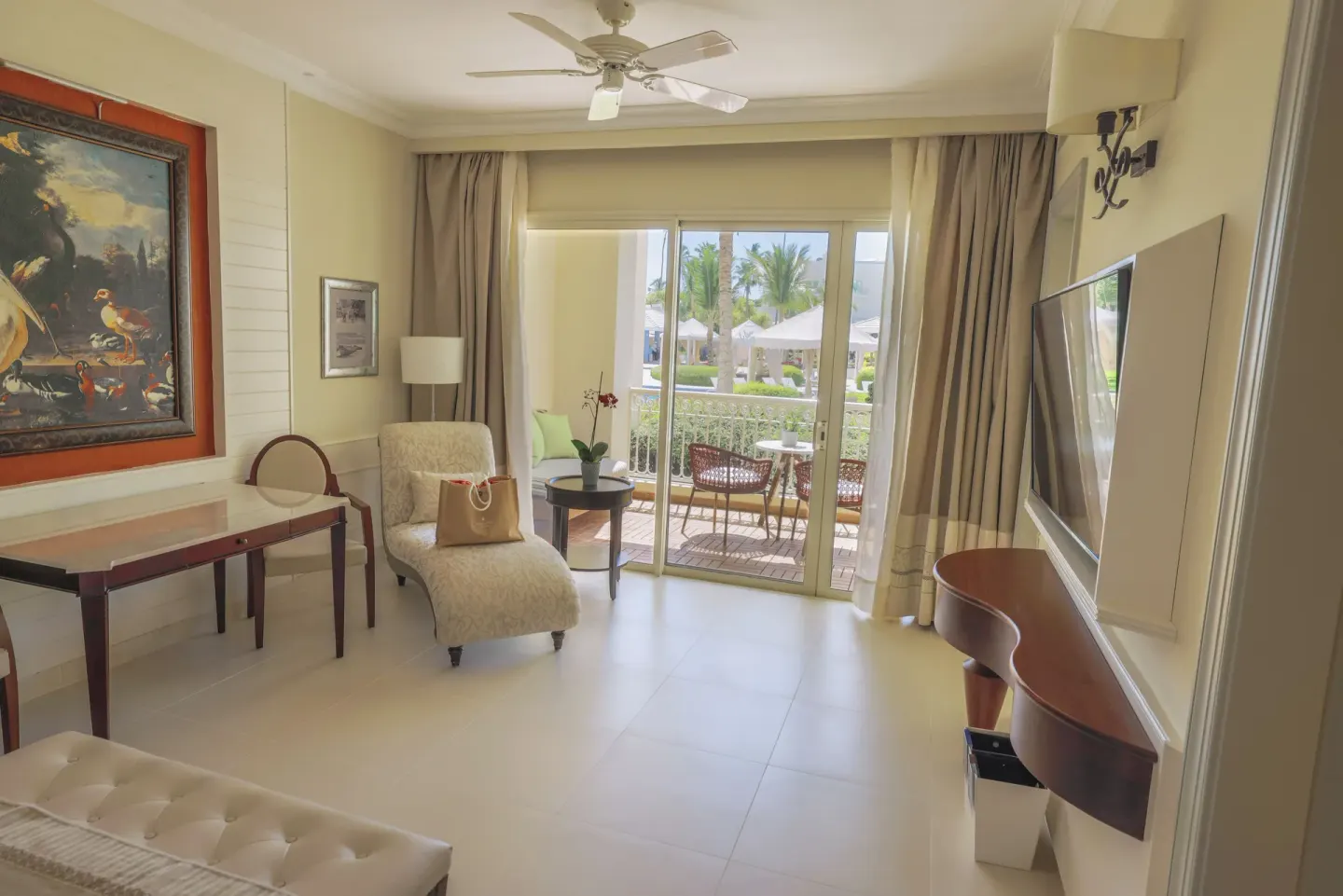 Suite Lake View sitting area with balcony doors at JOIA Bávaro by Iberostar.