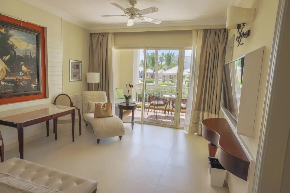 Suite Lake View sitting area with balcony doors at JOIA Bávaro by Iberostar.
