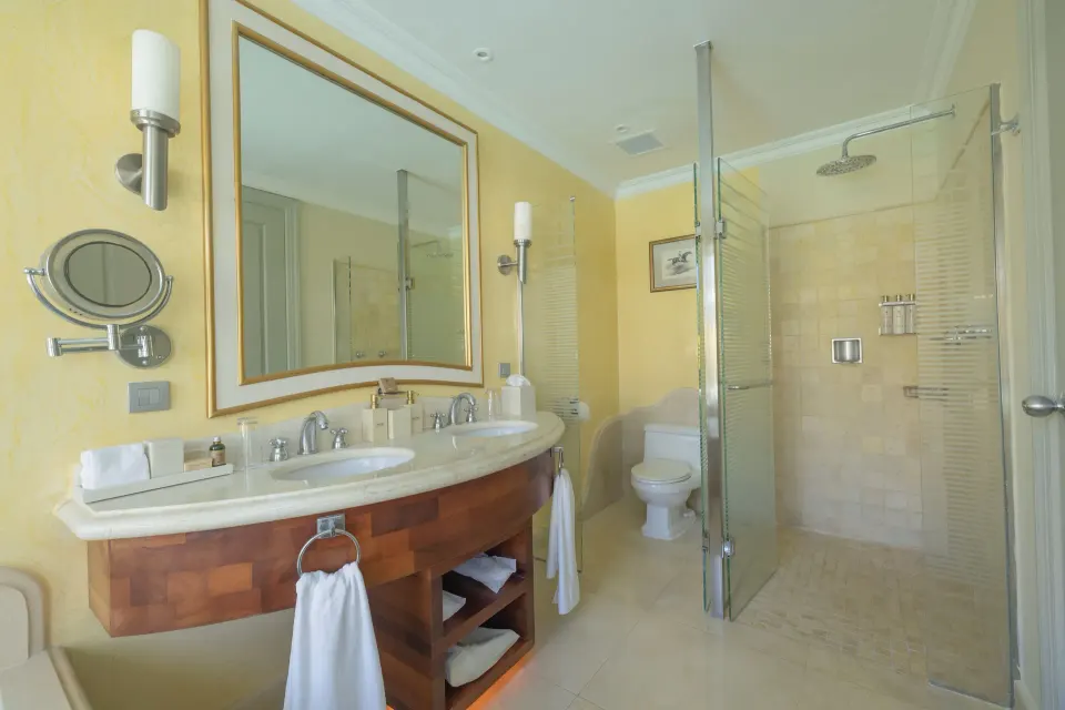 Ocean View Suite bathroom with double vanity and glass shower at JOIA Bávaro by Iberostar.
