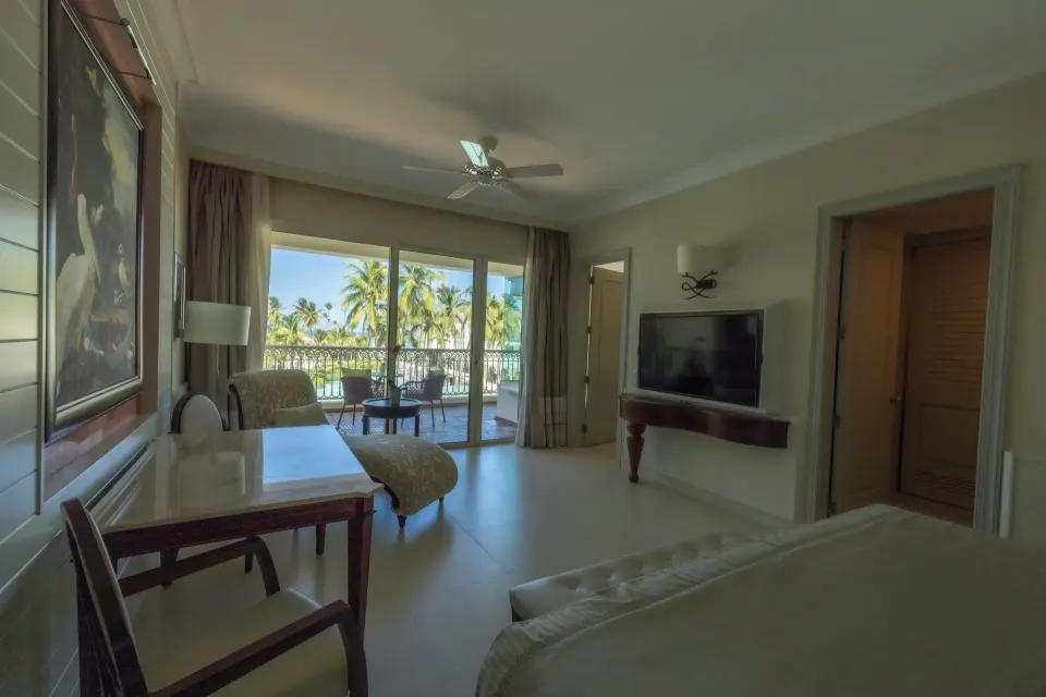 Ocean View Suite bedroom with balcony and palms at JOIA Bávaro by Iberostar.