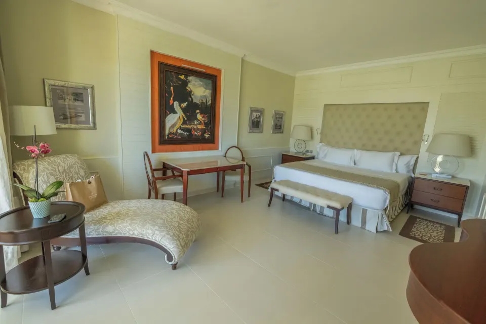 Ocean View Suite king bedroom with chaise lounge at JOIA Bávaro by Iberostar.