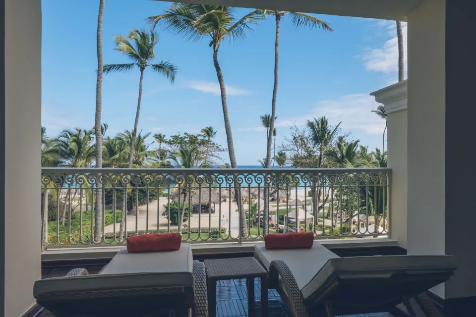 Oceanfront suite balcony loungers and palm view at JOIA Bávaro by Iberostar.