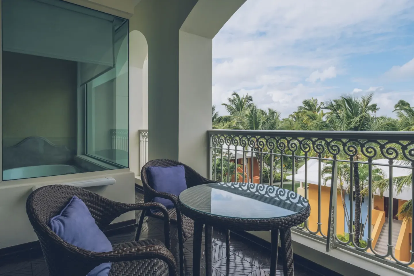 Suite upper floor balcony with wicker chairs at JOIA Bávaro by Iberostar.