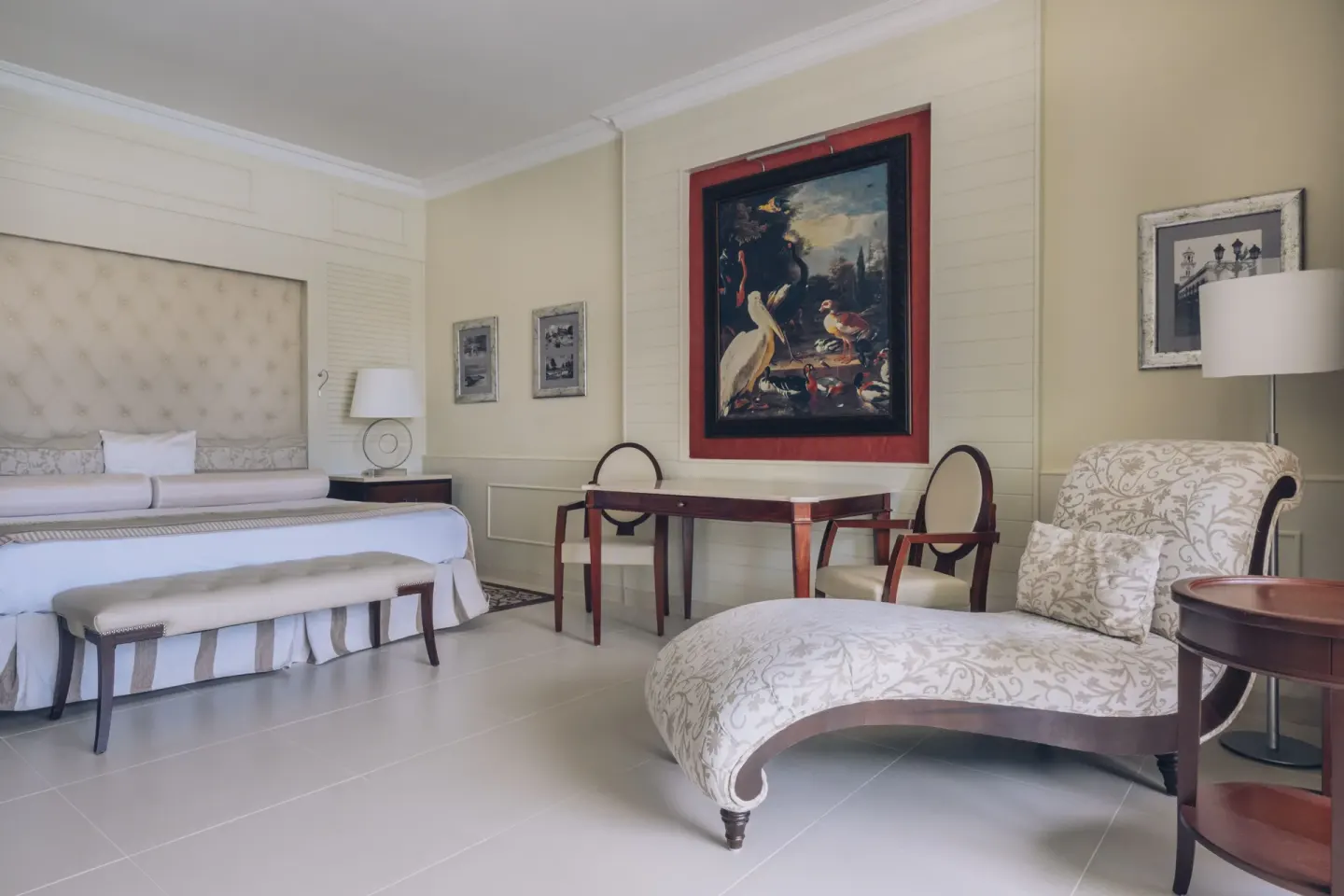 Suite seating area with king bed, chaise lounge and table at JOIA Bávaro by Iberostar.