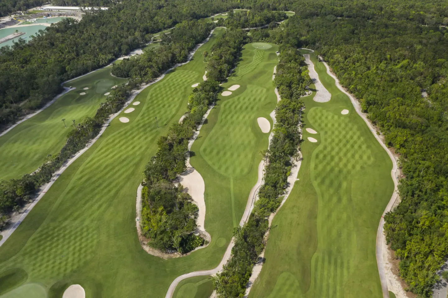 Aerial view of golf fairways, bunkers, and surrounding forest near JOIA Paraíso by Iberostar.