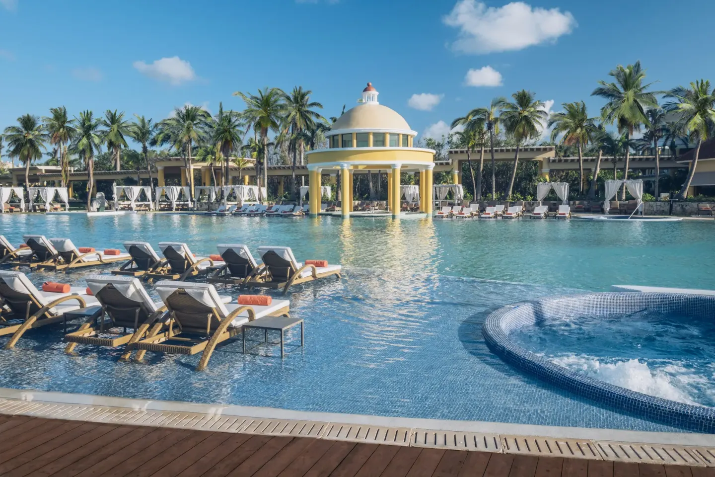 Pool loungers, bubbling spa tub, and domed pavilion at JOIA Paraíso by Iberostar.