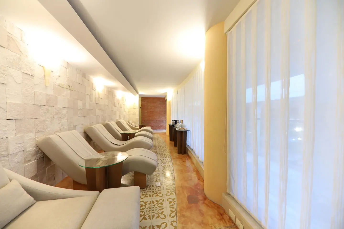 Spa relaxation lounge with recliners and sheer window curtains at JOIA Paraíso by Iberostar.