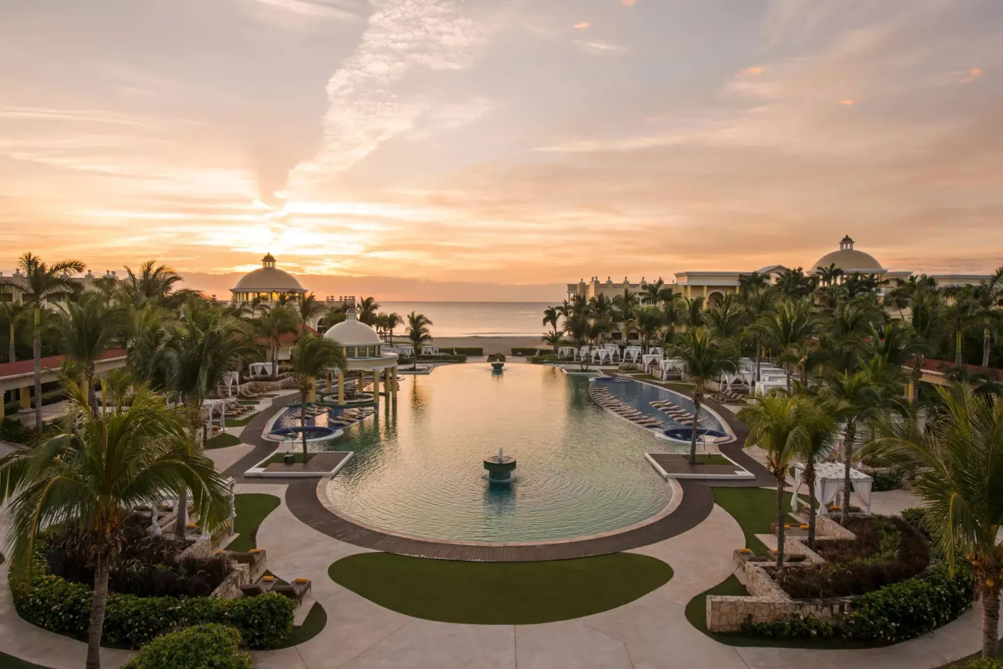 Sunset view over the central pool and ocean at JOIA Paraíso by Iberostar.