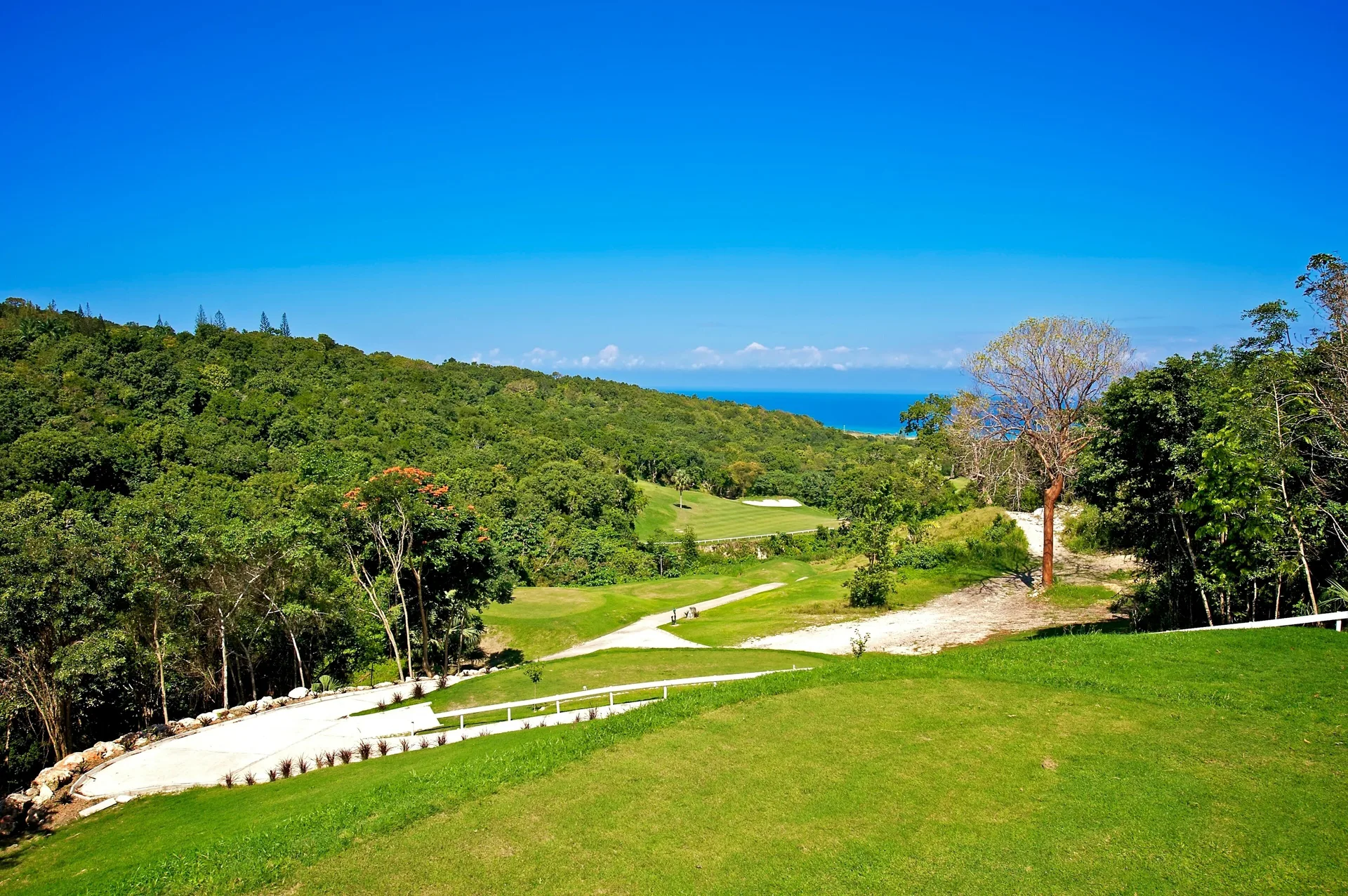 Green golf course fairways overlook the sea near JOIA Rose Hall by Iberostar.
