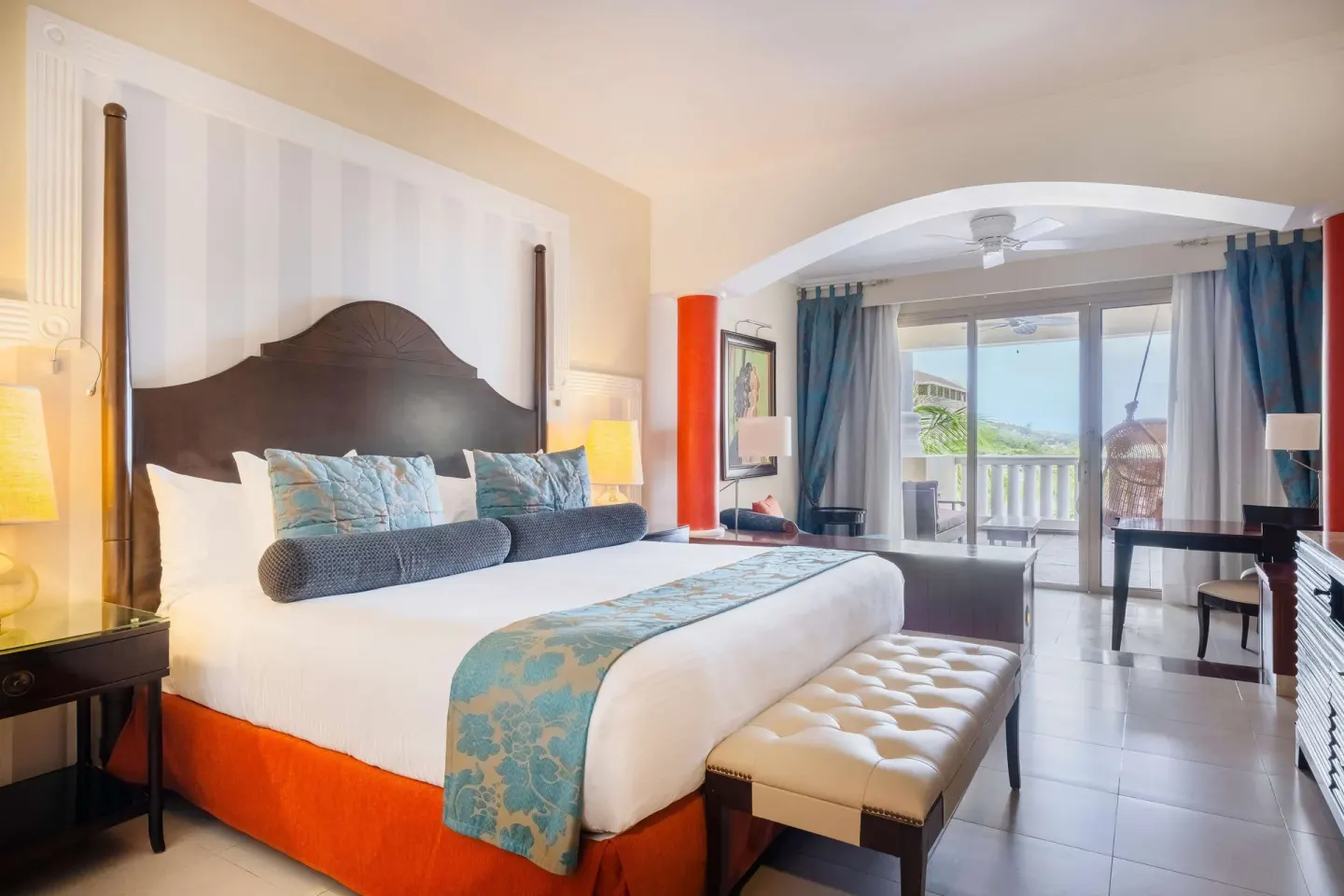 King guest room with balcony seating and ocean glimpse at JOIA Rose Hall by Iberostar.