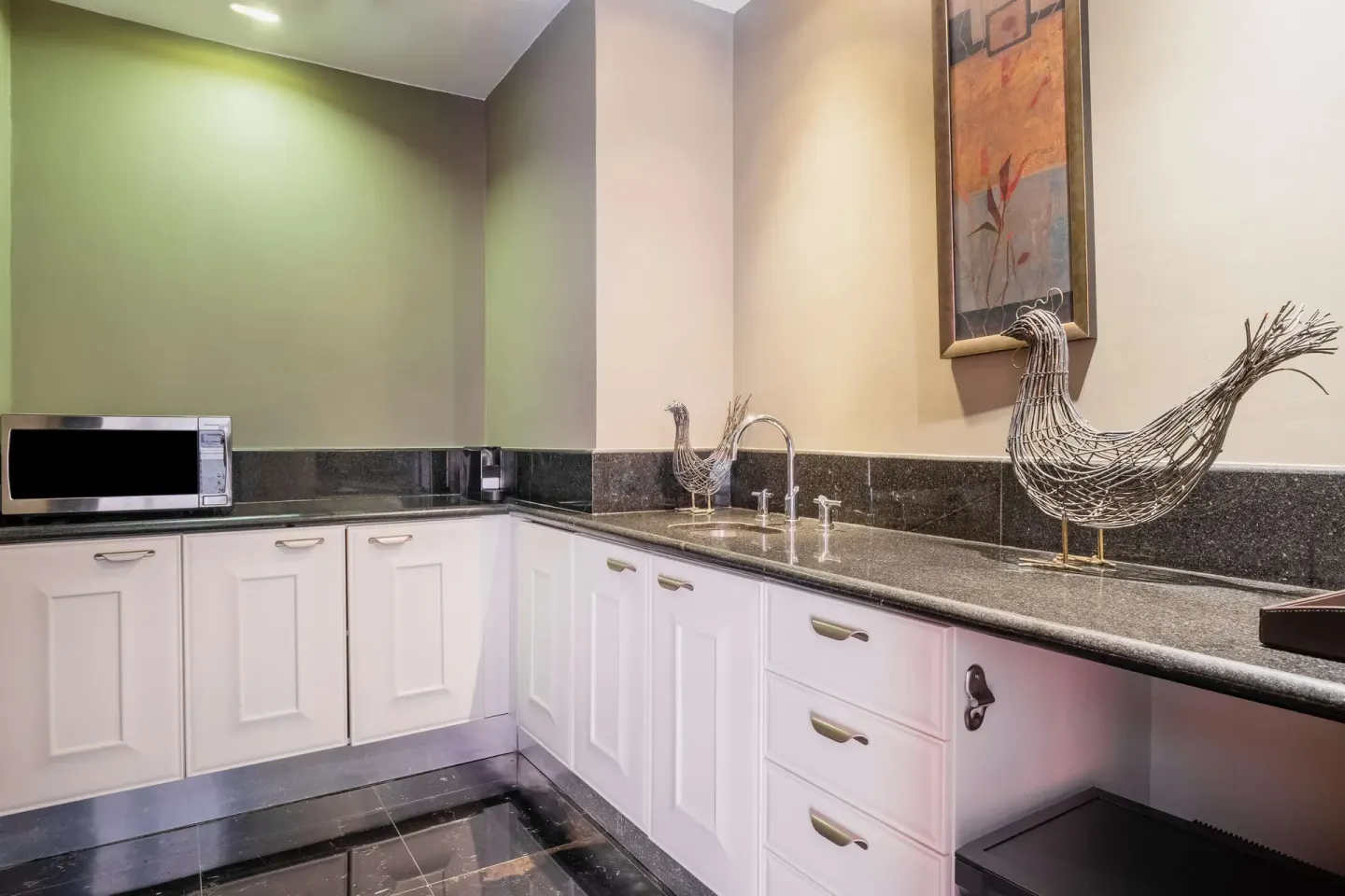 Guest kitchenette with sink, microwave and counter decor at JOIA Rose Hall by Iberostar.