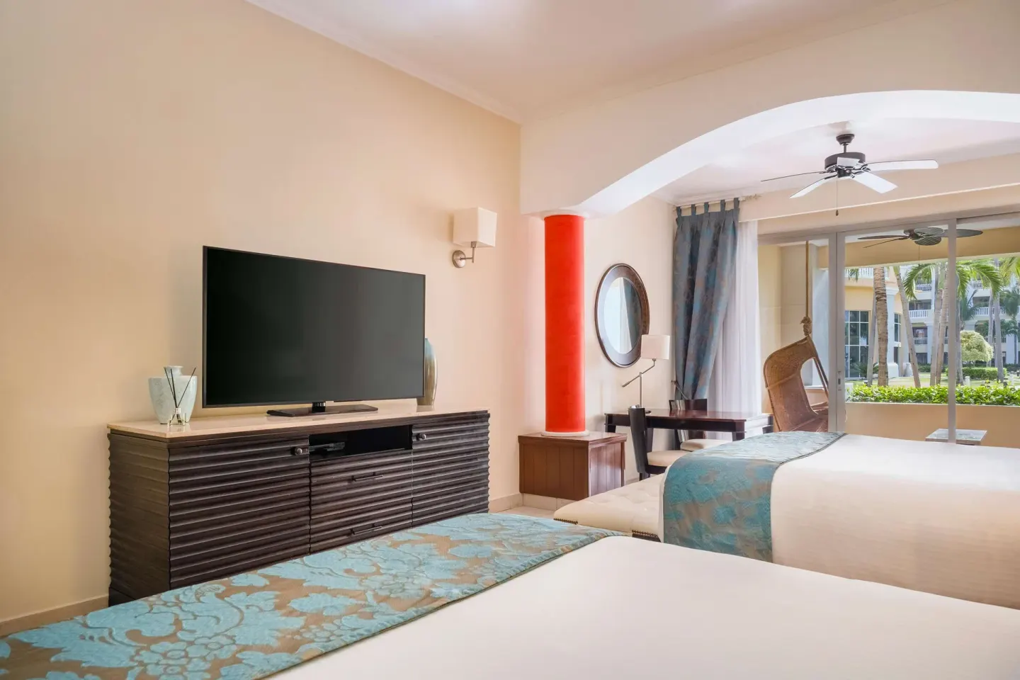 Guest room with two beds, TV, and balcony view at JOIA Rose Hall by Iberostar.