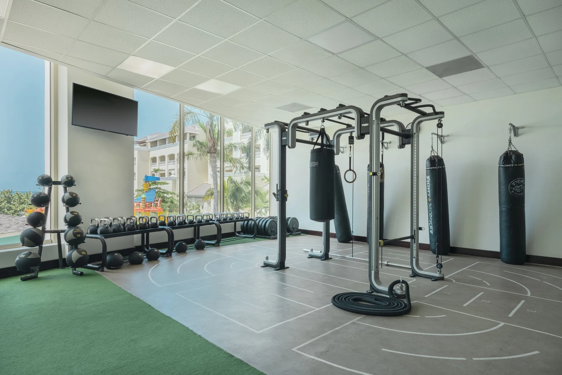 Gym corner with kettlebells, punching bags and large windows at JOIA Rose Hall by Iberostar.