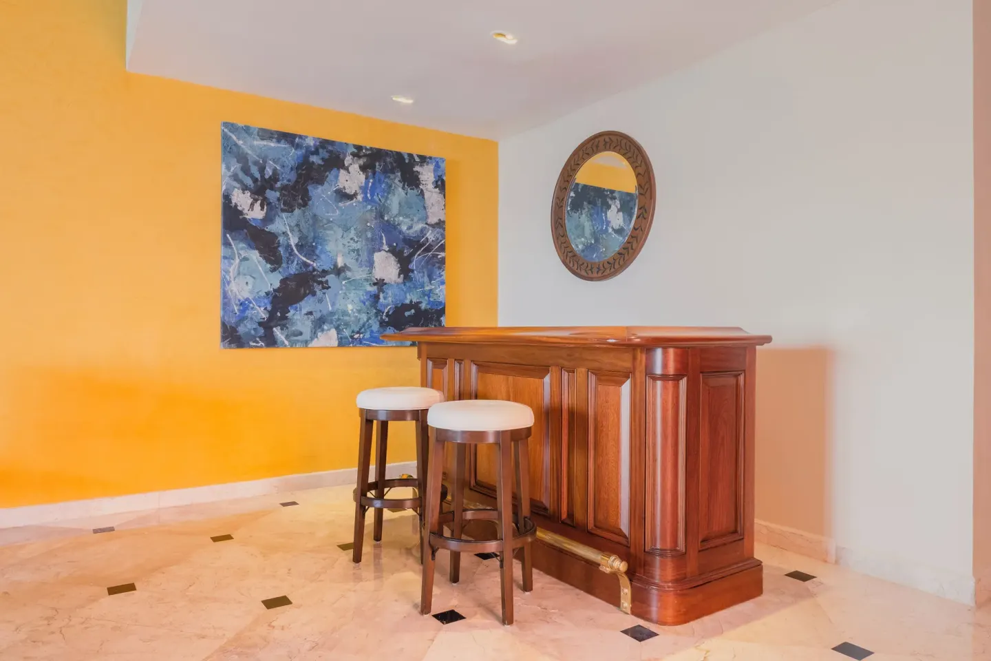 Private in-suite bar with stools and abstract art at JOIA Rose Hall by Iberostar.