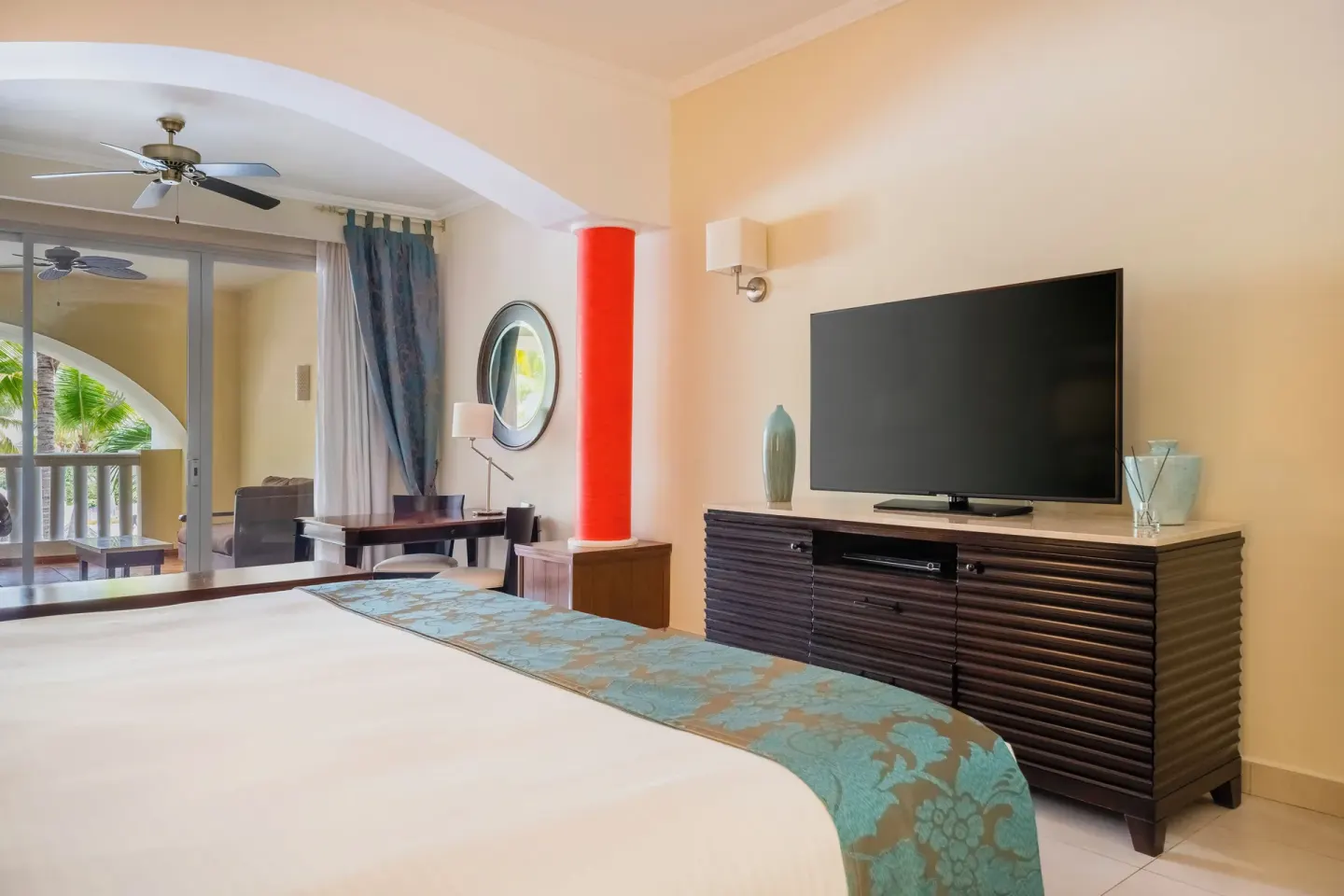 Guest room with king bed, TV console and balcony at JOIA Rose Hall by Iberostar.