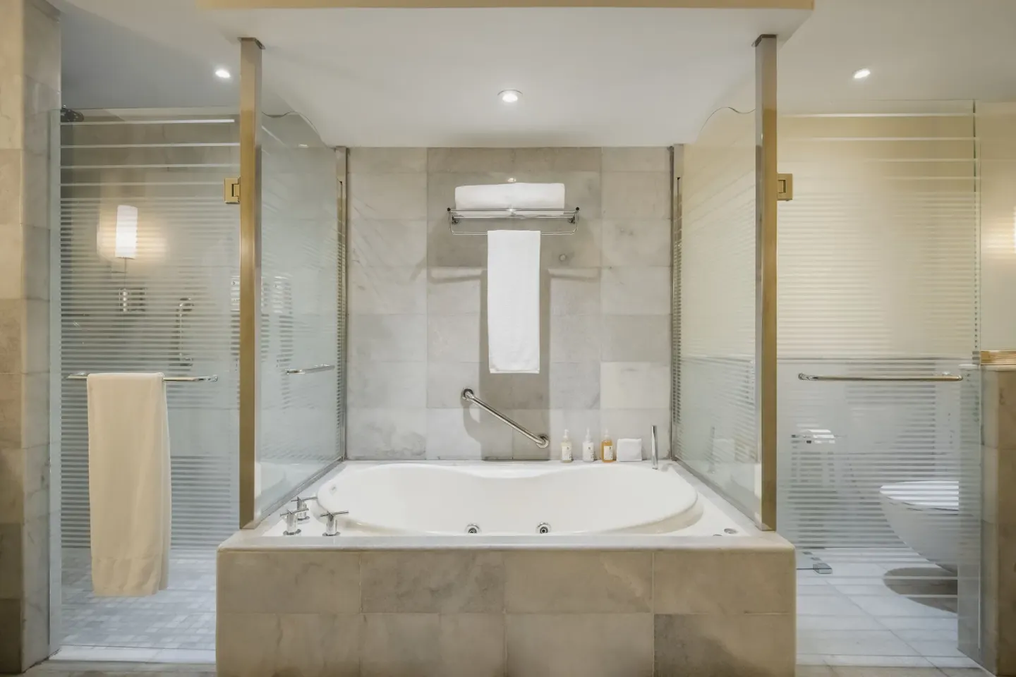 Marble bathroom with jetted tub and glass shower at JOIA Rose Hall by Iberostar.